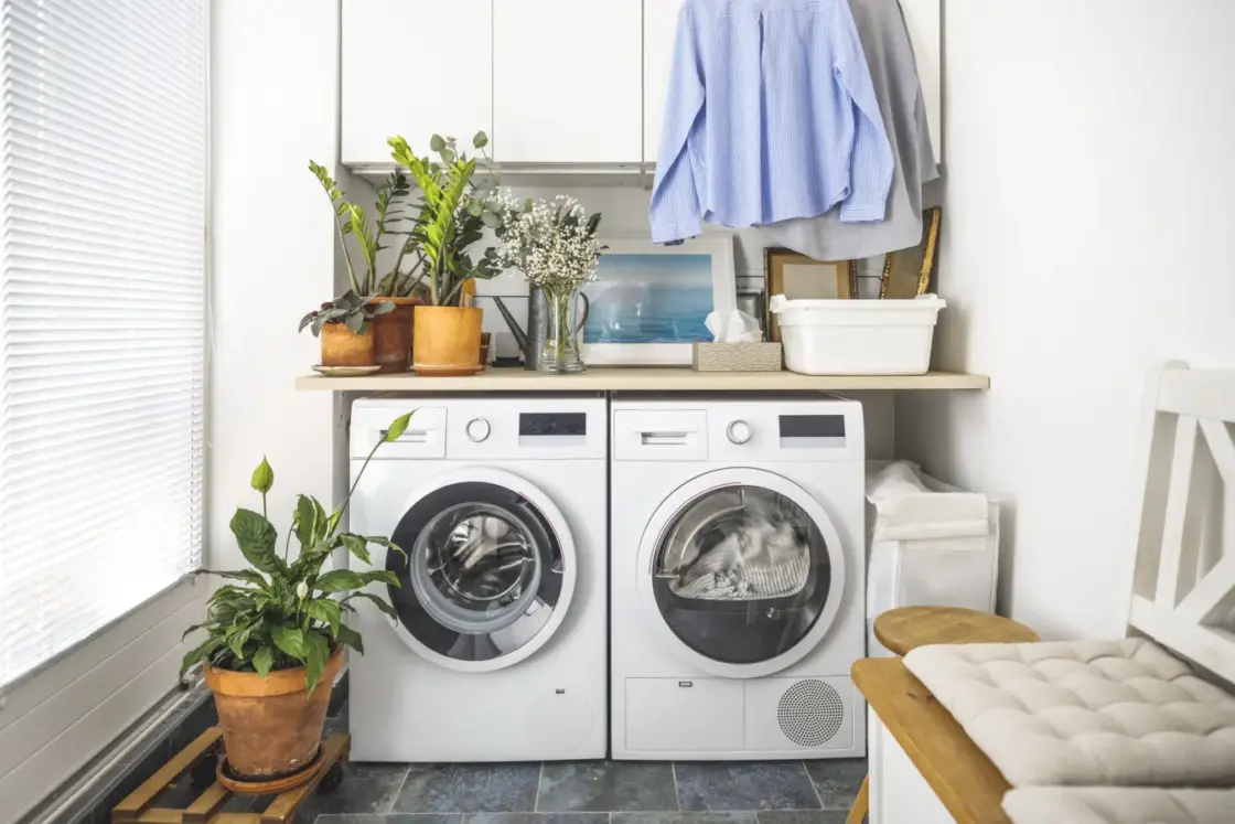 Laundry room with front load washer and dryer and hanging clean shirts. Promoting size water softener.