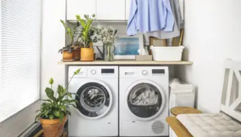 Laundry room with front load washer and dryer and hanging clean shirts. Promoting size water softener.